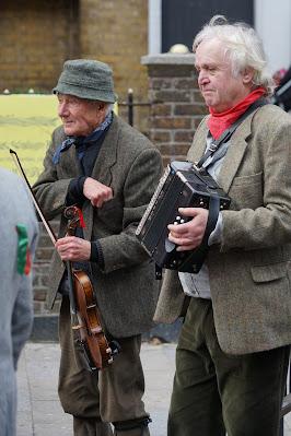 Photograph of two men, one holding a fiddle and the other playing an accordion