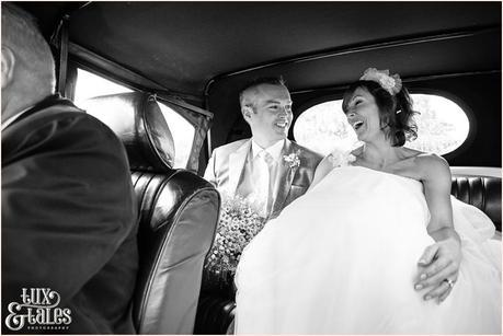 bride and groom riding in vintage car in the lake district