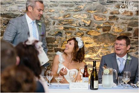 Bride smiles at groom during wedding speech