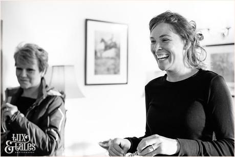 blacka nd white photo taken during bridal preparations of a friend smiling 