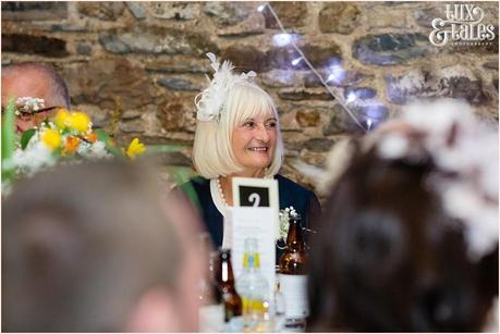 Mother of the groom smiles during ths peeches at barn wedding 