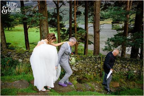 Bride, groom and chauffeur walking down the mountain at lake buttermere