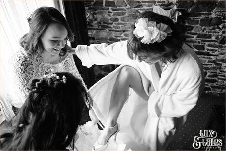 Bride steps into wedding dress at New House Farm wedding in the Lake district