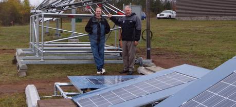 Michigan Tech solar energy scientist Joshua Pearce, left, and Jay Meldrum, director of the Keweenaw Research Center, with the array of solar panels behind KRC. Even on this gloomy day, they were cranking out electricity.