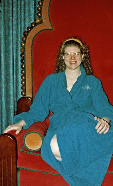 Woman in bathrobe sitting on a large red chair