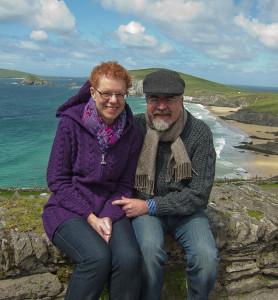 Woman and man on stone wall overlooking beach scene