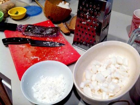 knife, graters with grated and chopped coconut on kitchen counter