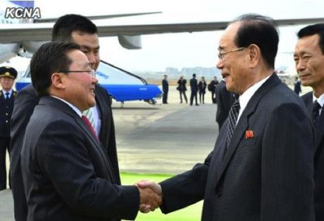 Mongolian President Tsakhiagiin Elbegdorj (L) shakes hands with SPA Presidium President Kim Yong Nam (R) after arrving at Pyongyang Airport on 28 October 2013 for a four-day visit to the DPRK (Photo: KCNA).