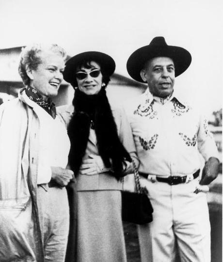 Mademoiselle Gabrielle “Coco” Chanel attends a Western party at Mr. Stanley Marcus’ brother Eddie’s Blackmark Farm in Dallas. Chanel came to Dallas to receive the Neiman Marcus Award for Distinguished Service in the Field of Fashion in 1957 (she was the sole recipient). In the photo (left to right) Mrs. Stanley “Billie” Marcus, Mademoiselle Gabrielle “Coco” Chanel and Mr. Stanley Marcus. 