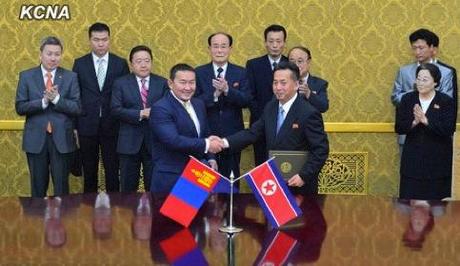Mongolian Minister of Industry and Agriculture Khaltmaa Battulga (L) shakes hands with DPRK Minister of Foreign Trade Ri Ryong Nam (R) after signing an economic cooperation agreement at Mansudae Assembly Hall in Pyongyang on 28 October 2013 (Photo: KCNA).