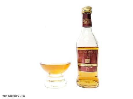 White background tasting shot with the Glenmorangie Lasanta 12 Years bottle and a glass of whiskey next to it.