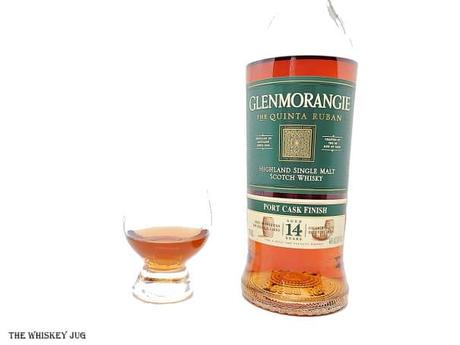 White background tasting shot with the Glenmorangie Quinta Ruban 14 Years bottle and a glass of whiskey next to it.