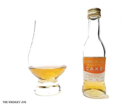 White background tasting shot with the Glenmorangie A Tale Of Cake bottle and a glass of whiskey next to it.