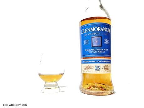 White background tasting shot with the Glenmorangie Cadboll Estate 15 Years bottle and a glass of whiskey next to it.