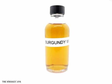 White background tasting shot with the Glenmorangie Burgundy Wood 12 Years sample bottle.