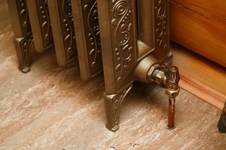 Close up of radiator valve and rad tail at foot of retro cast iron radiator