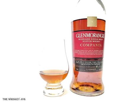 White background tasting shot with the Glenmorangie Companta bottle and a glass of whiskey next to it.