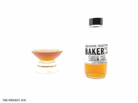 White background tasting shot with the Baker's Exclusive Selection 11 Years sample bottle and a glass of whiskey next to it.