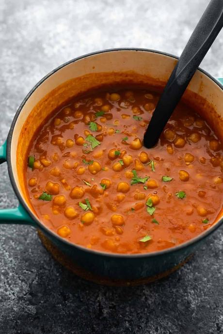 chickpea curry in blue pot with spoon