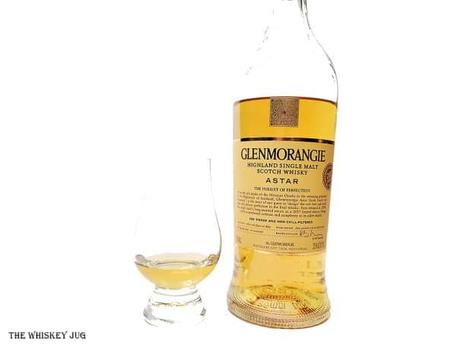 White background tasting shot with the Glenmorangie Astar bottle and a glass of whiskey next to it.