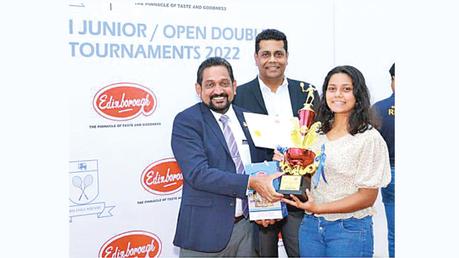 Shenaya Siriwardena (right) receiving the Under 19 Girls Trophy from the Strategic Advisor of Edinborough Products (Pvt) Ltd Nandana Wickramage (left). The President of Sri Lanka Squash Suren Kohombange is also present (center).