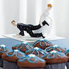 A funny cake topper with an bride carrying the groom by the leg