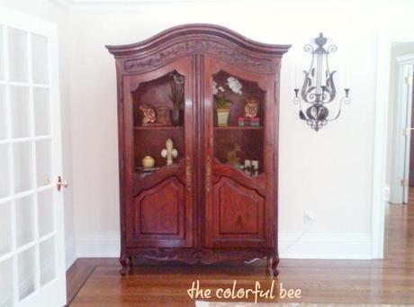 antique armoire in a staged master bedroom
