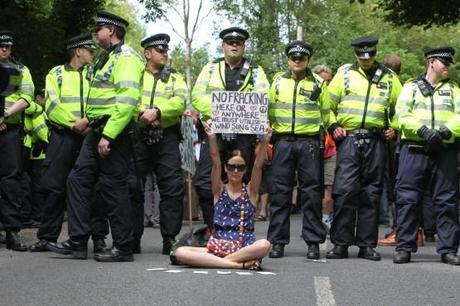 A woman holds up a placard during an anti-fracking protest march against the energy company Cuadrilla on August 18, 2013 in Balcombe, UK. Credit: Randi Sokoloff