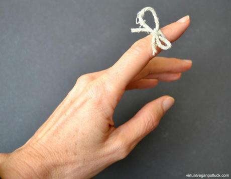 Finger with string tied on it.