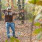 Boy Shooting Compound Bow In Woods