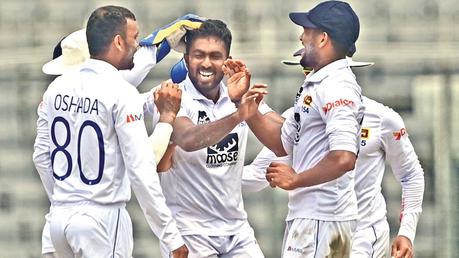 Asitha Fernando is congratulated by his teammates.