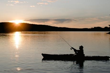Sunset view with a man fishing calmly on boat