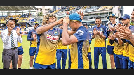 The 28-year-old debutant paceman Pramod Madushan receiving his ODI cap from Fast Bowling Strategy Coach Lasith Malinga before the start of the fifth ODI against Australia yesterday. Team Manager Mahinda Halangoda and team members are also in the picture.