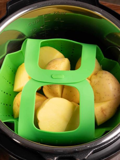 An instant pot with strainer filled with Yukon gold potatoes
