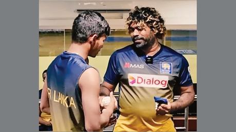 Lasith Malinga handing over a surprise gift souvenir ball to young Dunith Wellalage at the players dressing room at the R. Premadasa International Cricket Stadium last Friday.     