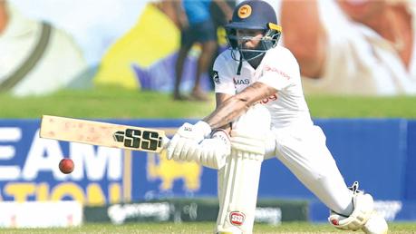 Niroshan Dikwella who scored his 21st Test half century playing a reverse sweep during his fighting knock at the first Test yesterday. (Pix courtesy SLC)