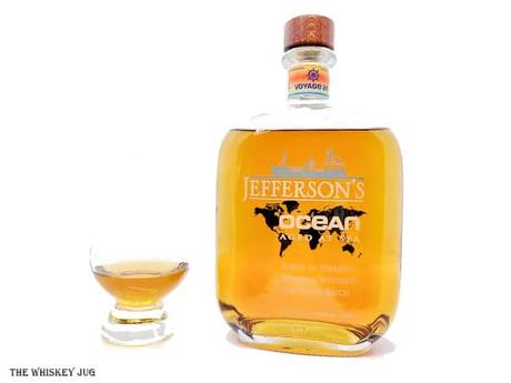 White background tasting shot with the Jefferson's Ocean Voyage 24 bottle and a glass of whiskey next to it.