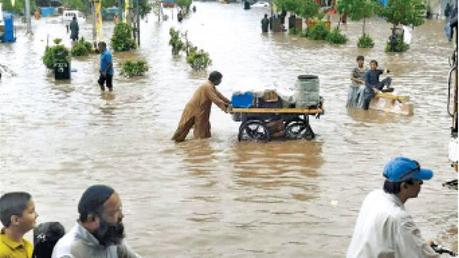 People wade through a flooded area after a monsoon rainfall in Quetta, Pakistan  on Wednesday. 