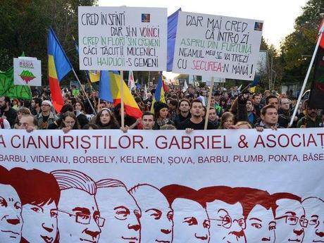 Protesters hold a banner with Romanian politicians in favor of a gold mine project during a demonstration in Bucharest against the Canadian gold mine project in October. 