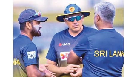 Sri Lankan head coach Chris Silverwood (centre) chat with skipper Dimuth  Karunaratne and chief selector Promodya Wickramasinghe during the training session at Galle    