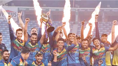 Victorious Sri Lankan cricketers celebrate with the trophy