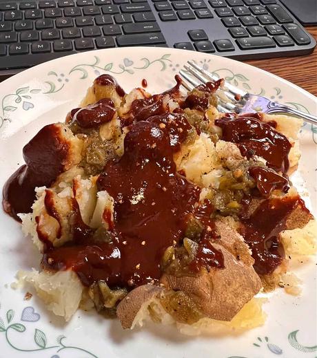 plate of cooked  potatoes covered in New Mexican red Chile sauce 