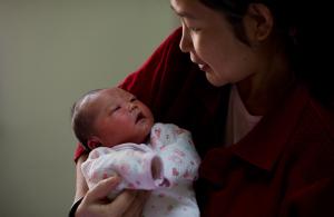 Yu Qiuyan (R) holds her newborn baby gir