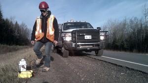 A worker with SWN Resources Canada contractor Geokinetics walks toward a geophone on the shoulder of Hwy 11 in New Brunswick. APTN/Photo