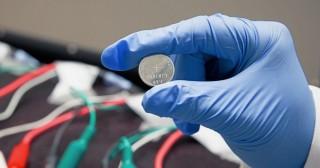 This prototype lithium ion battery, made in a Stanford lab, contains a silicon electrode protected with a coating of self-healing polymer. The cables and clips in the background are part of an apparatus for testing the performance of batteries during multiple charge-discharge cycles.