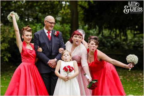 Bride, groom and daughters make funny faces at red themed vintage wedding in Yorkshire