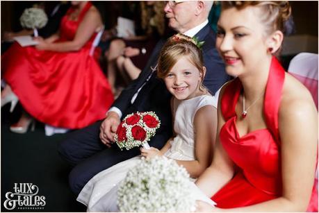 Bridesmaid smiles during wedding ceremony at Yorkshire vintage thmed red heart details 