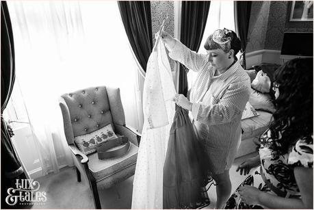 Bride looks at courutre company dress before she puts it on at vintage themed wedding in Yorkshire