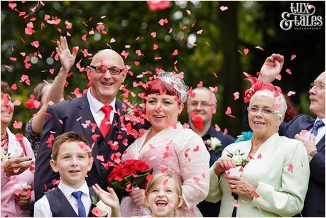 Couple showered inr ed heart confetti at vintage themed wedding in Yorkshire 