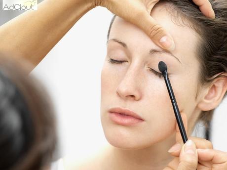 Woman having eye shadow applied